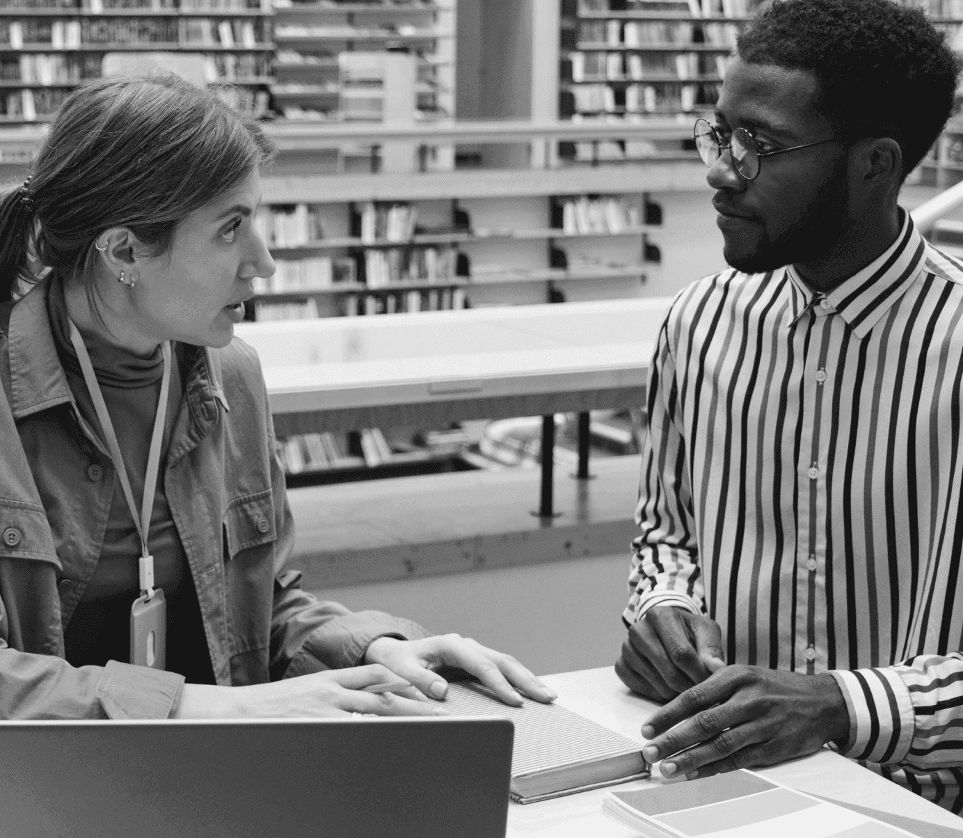 An image showing two researchers in a library, talking to each other